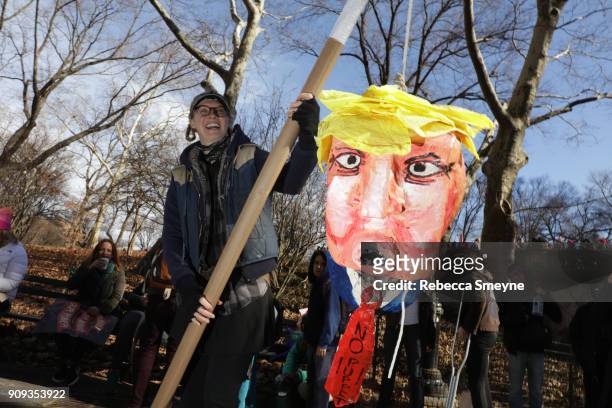 Woman holds a pinata version of Donald Trump at Central Park West on January 20, 2018 in New York City.