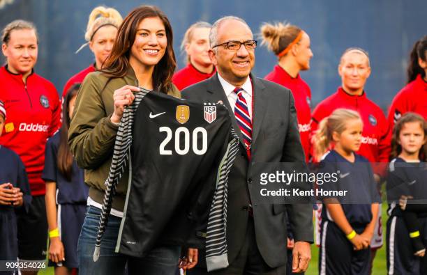 Hope Solo is presented with commemorative items honoring her 200th cap by U.S. Soccer Vice President Carlos Cordeiro the field during pregame...