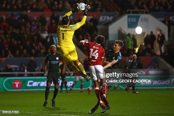 Manchester City's Chilean goalkeeper Claudio Bravo catches the ball under pressureform Bristol City's English striker Bobby Reid during the English...