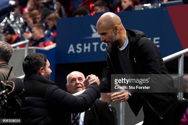 Lee Johnson, manager of Bristol City and Josep Guardiola, Manager of Manchester City shake hands prior to the Carabao Cup semi-final second leg match...