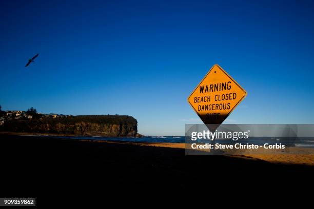 Beach Closed sign warning swimmers of the dangerous surf conditions during king tides at Mona Vale on January 18, 2018 in Sydney, Australia