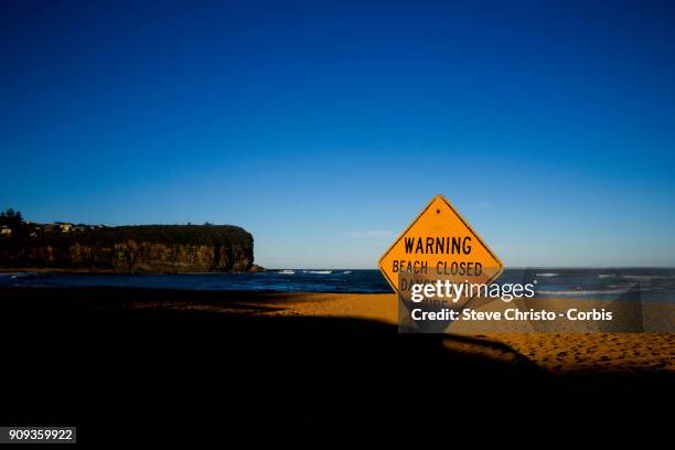 Beach Closed sign warning swimmers of the dangerous surf conditions during king tides at Mona Vale on January 18, 2018 in Sydney, Australia