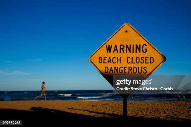 Beach Closed sign warning swimmers of the dangerous surf conditions during king tides at Mona Vale on January 18, 2018 in Sydney, Australia