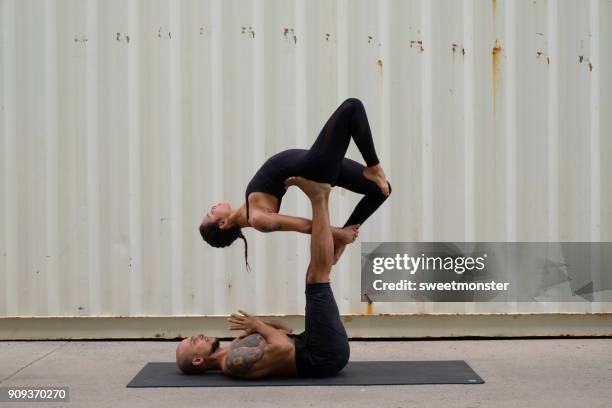 couple practicing acroyoga - acroyoga stock pictures, royalty-free photos & images