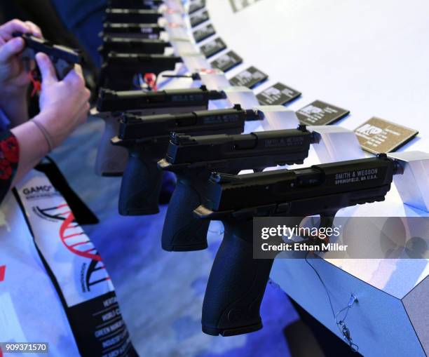 An attendee looks at handguns at the Smith & Wesson booth at the 2018 National Shooting Sports Foundation's Shooting, Hunting, Outdoor Trade Show at...