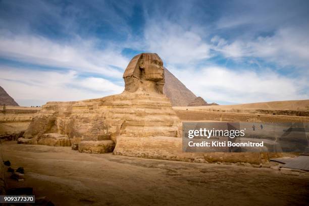 the spinx laying down in front of the great pyramid of giza in egypt - esfinge fotografías e imágenes de stock