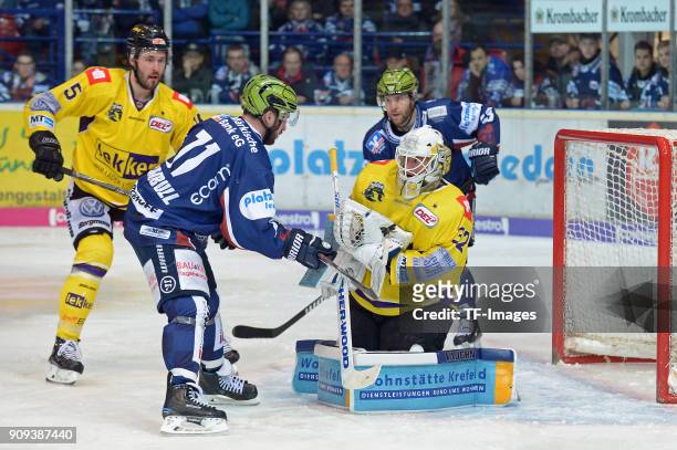 Chad Costello of Iserlohn and Goalkeeper Dimitri Paetzold of Krefeld Pinguine battle for the ball during the DEL match between Iserlohn Roosters and...