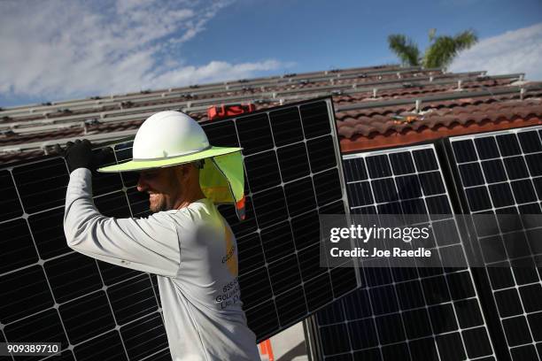Andres Hernandez, from the Goldin Solar company, installs a solar panel system on the roof of a home a day after the Trump administration announced...