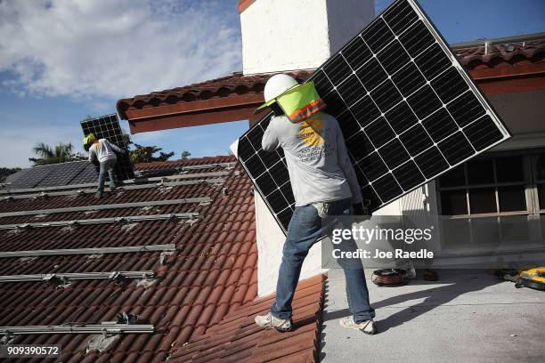 Andres Hernandez and Roger Garbey , from the Goldin Solar company, install a solar panel system on the roof of a home a day after the Trump...