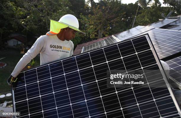 Roger Garbey, from the Goldin Solar company, installs a solar panel system on the roof of a home a day after the Trump administration announced it...