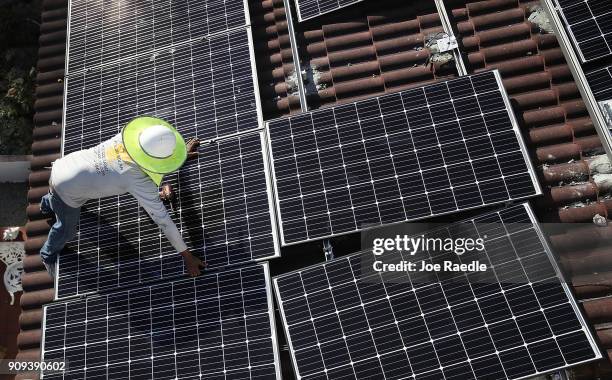 Roger Garbey, from the Goldin Solar company, installs a solar panel system on the roof of a home a day after the Trump administration announced it...