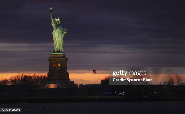 The Statue of Liberty stands in New York Harbor at sunset on January 23, 2018 in New York City. The national landmark only briefly closed due to the...