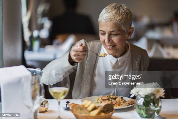 donna anziana felice che si gode il suo pranzo in un ristorante. - lunch lady foto e immagini stock
