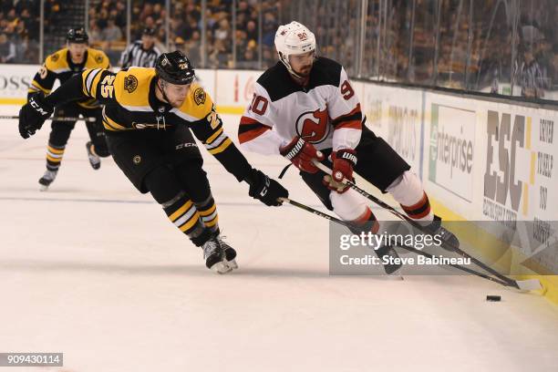 Brandon Carlo of the Boston Bruins reaches for the puck against Marcus Johansson of the New Jersey Devils at the TD Garden on January 23, 2018 in...