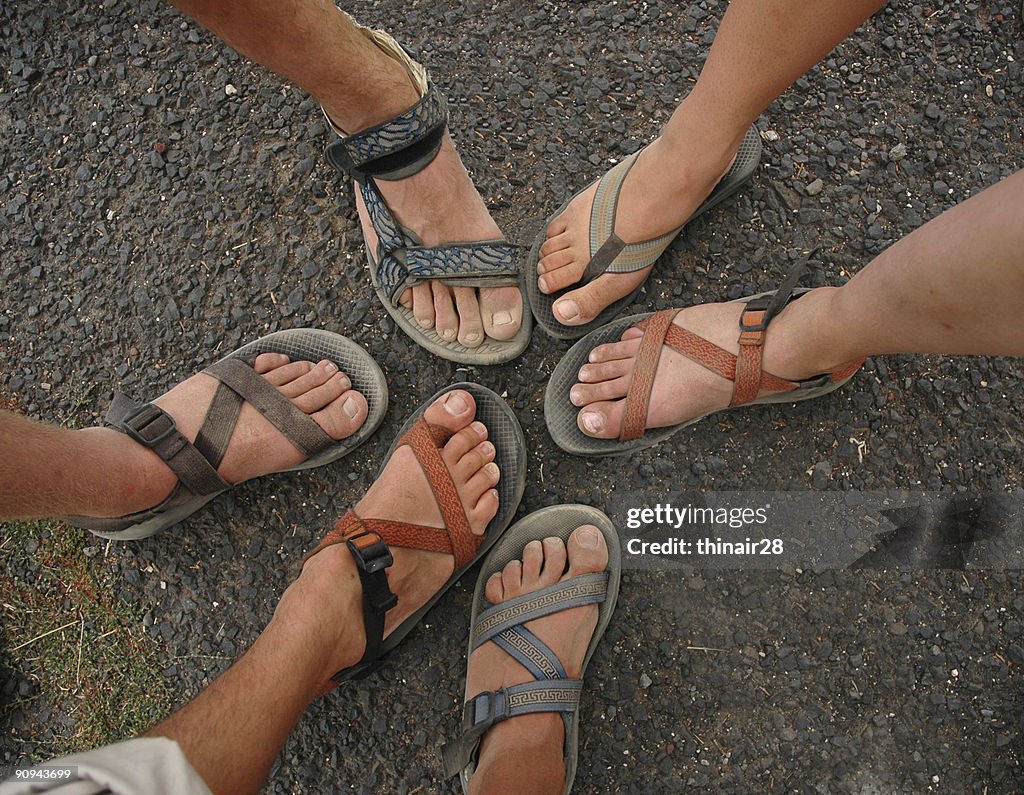 Many different feet and sandals form a circle