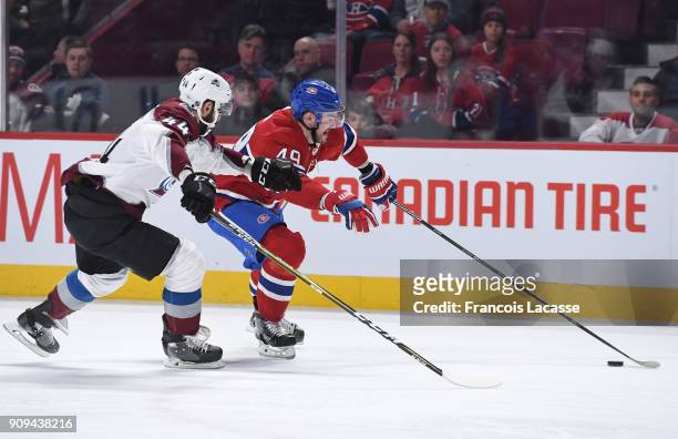 Logan Shaw of the Montreal Canadiens skates with the puck while being challenged by Mark Barberio of the Colorado Avalanche in the NHL game at the...