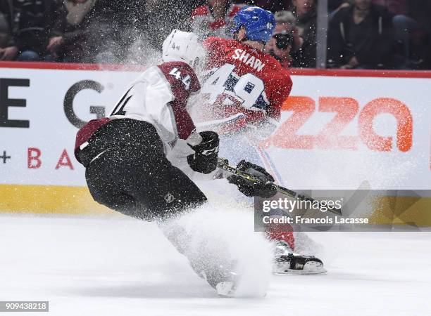 Logan Shaw of the Montreal Canadiens skates with the puck while being challenged by Mark Barberio of the Colorado Avalanche in the NHL game at the...