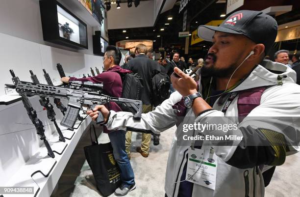 Paulo Rubio of Canada looks at a short-barreled rifle at the Sig Sauer booth at the 2018 National Shooting Sports Foundation's Shooting, Hunting,...