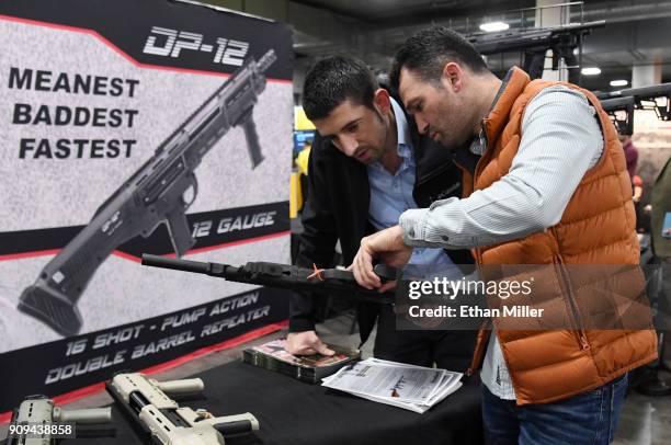 Osman Gulle and Ibrahim Ozerbas, both of Turkey, look at a SKO-BULL semi-automatic shotgun at the Standard Manufacturing Co. Booth at the 2018...