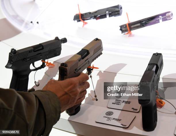 Convention attendee looks at a handgun at the Sig Sauer booth at the 2018 National Shooting Sports Foundation's Shooting, Hunting, Outdoor Trade Show...