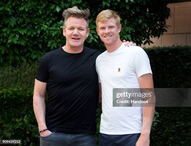 In this handout provided by Tennis Australia, Kyle Edmund of Great Britain poses with Gordon Ramsay during day 10 of the 2018 Australian Open on...