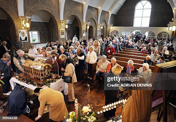 People queue to pray before the case containing the Relics of St. Therese of Liseux at St. Teresa of Liseaux church in Taunton, west England on...