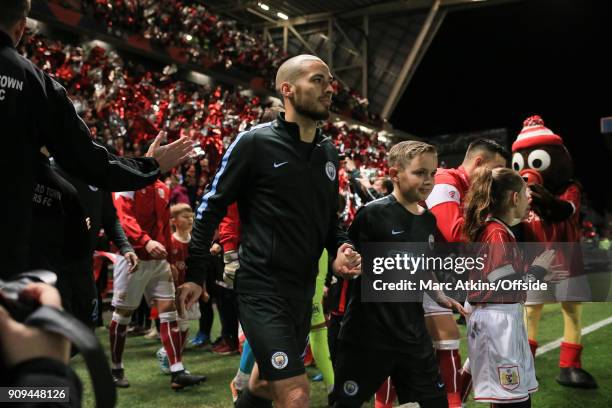 David Silva walks out alongside a mascot prior to the Carabao Cup Semi-Final 2nd leg match between Bristol City and Manchester City at Ashton Gate on...