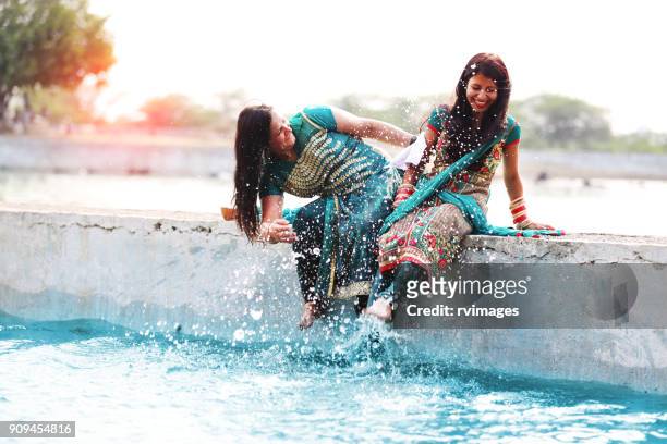 due donne che si divertono nell'acqua del lago - indian female feet foto e immagini stock