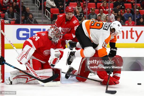 Nolan Patrick of the Philadelphia Flyers battles for the puck between Petr Mrazek and Nick Jensen of the Detroit Red Wings during the third period at...