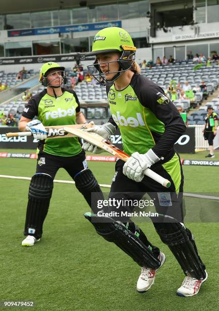 Rachel Haynes and Rachel Priest of the Thunder run onto the field during the Women's Big Bash League match between the Sydney Thunder and the...