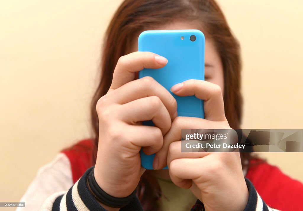 OBSESSIVE TEENAGER TEXTING ON SMART PHONE