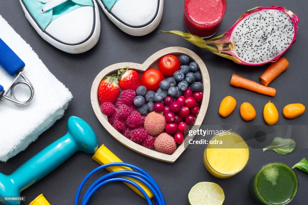 Healthy heart diet and sport gym equipment concept on blackboard