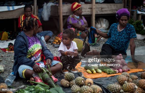 Papuan women sell fruit and vegetables on a street market in Timika in Indonesia's easternmost Papua province on January 24, 2018. / AFP PHOTO / Bay...