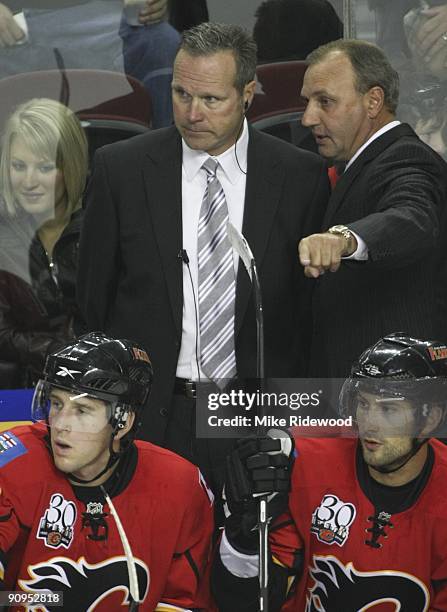 Coach Brent Sutter and assistant coach Dave Lowry of the Calgary Flames confer on the bench during a game against the Edmonton Oilers in the first...