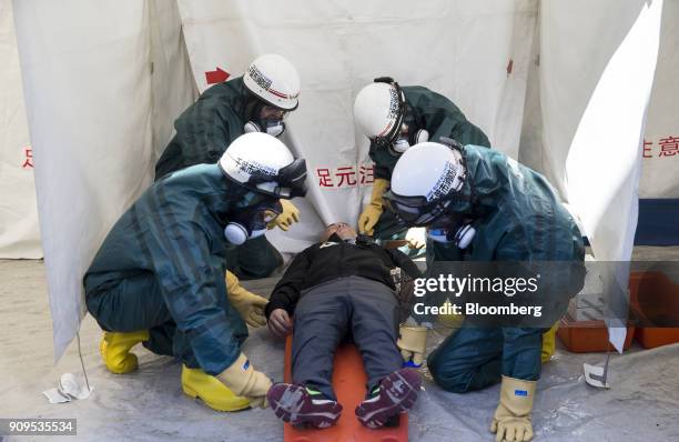 Members of the Chiba City Fire Department treat a participant acting injured during a sarin attack drill at a hospital in Chiba, Japan, on Wednesday,...