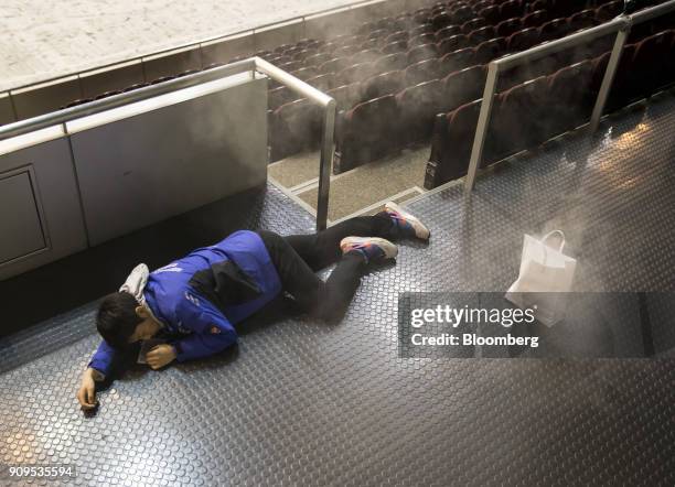 Smoke rises from a bag as a participant acting injured lies during a sarin attack drill at the Makuhari Messe convention center in Chiba, Japan, on...