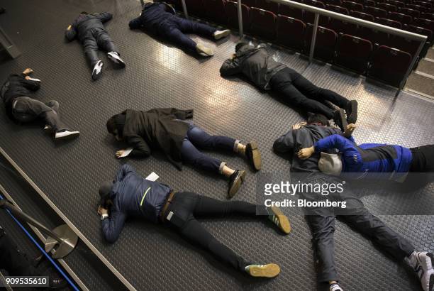 Participants acting injured lie during a sarin attack drill at the Makuhari Messe convention center in Chiba, Japan, on Wednesday, Jan. 24, 2018....