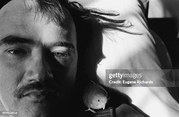 Close-up of an inmate and his pet parakeet in a bed at Lima State Hospital , Lima, Ohio, 1981. He had been convicted of killing his landlady. The...