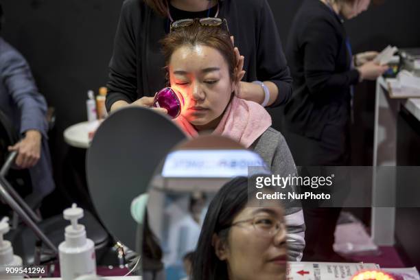 Woman tries machine for skin care during the Cosme Tokyo 2018, January 24, 2018 in Japan. Cosme Tokyo 2018 and the Asia's leading exhibition...
