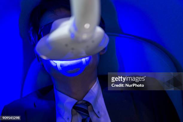 Man tries machine to make teeth whiter during the Cosme Tokyo 2018, January 24, 2018 in Japan. Cosme Tokyo 2018 and the Asia's leading exhibition...