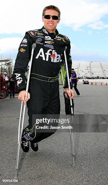 Carl Edwards, driver of the AFLAC Ford walks through the garage area on crutches during practice for the NASCAR Sprint Cup Series Sylvania 300 at the...