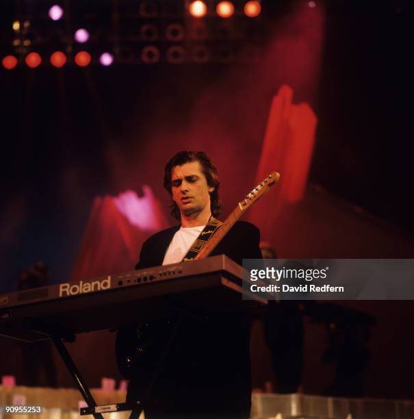 Mike Oldfield performs on stage in 1989. He is playing a Roland keyboard.