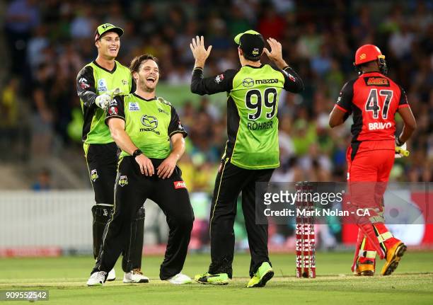Mitchell McClenaghan of the Thunder celebrates getting the wicket of Dwayne Bravo of the Renegades during the Big Bash League match between the...