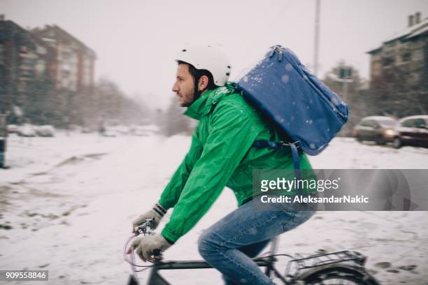 lieferung mann auf einem fahrrad - arbeiter winter stock-fotos und bilder