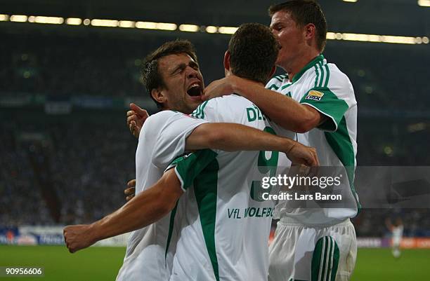 Edin Dzeko of Wolfsburg celebrates with team mates Alexander Madlung and Zvjezdan Misimovic after scoring the opening goal of Wolfsburg during the...