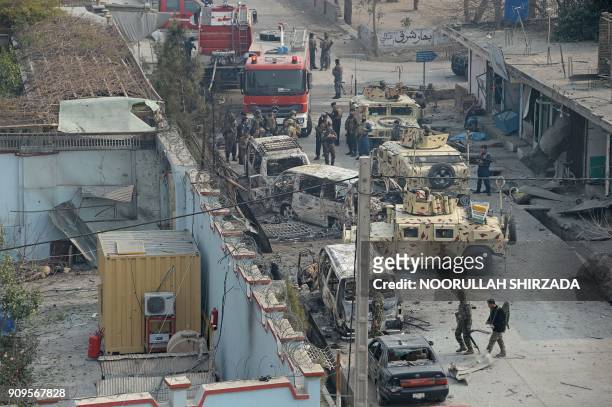 Afghan security personnels gather near an office of the British charity Save the Children after an attack in Jalalabad on January 24, 2018. Gunmen...