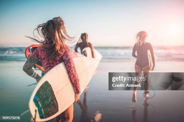 與他們的衝浪的朋友跑入海洋 - gold coast queensland 個照片及圖片檔