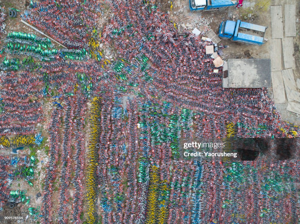 Abandonded Coloured ride-sharing bicycles sit in a pile in Shanghai