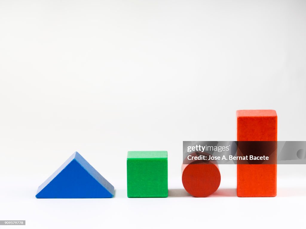 Group of objects of different geometric forms of wood, triangle, cube, circle and rectangle on a white background.