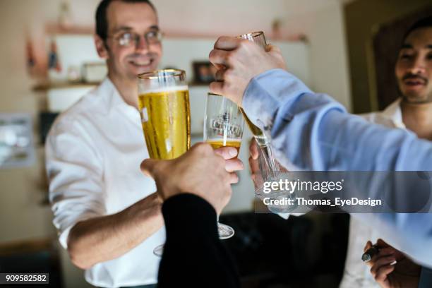 group of friends cheersing each other in cigar lounge - chink eye stock pictures, royalty-free photos & images